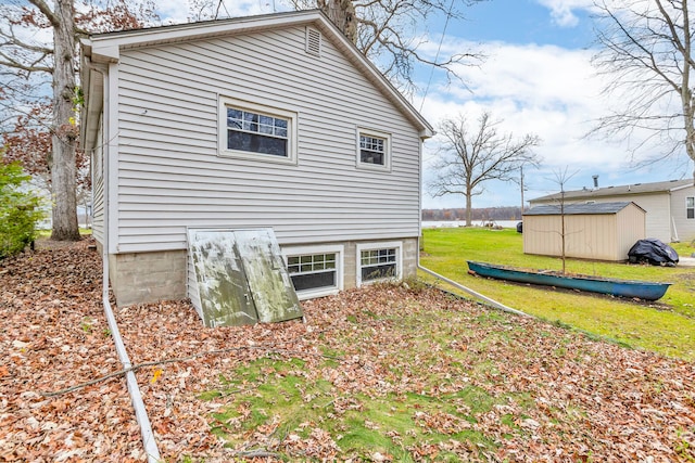 back of property with a lawn and a water view