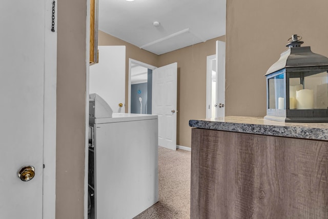 kitchen with light colored carpet and washer / dryer