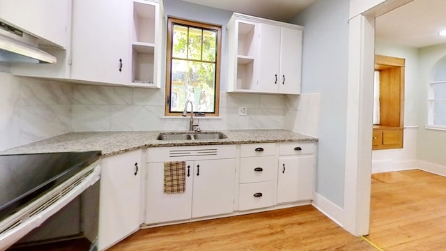 kitchen featuring sink, white cabinetry, light wood-type flooring, backsplash, and exhaust hood