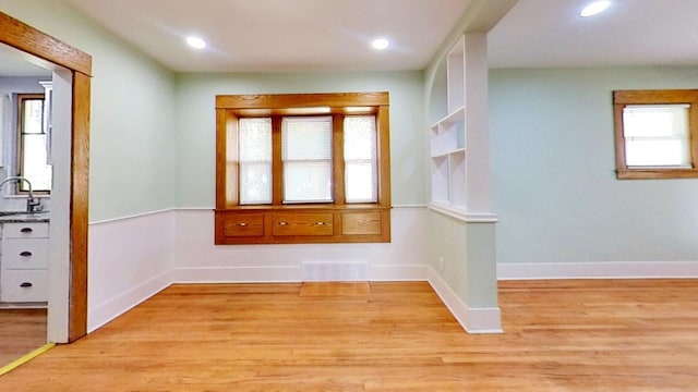 spare room featuring sink and light wood-type flooring