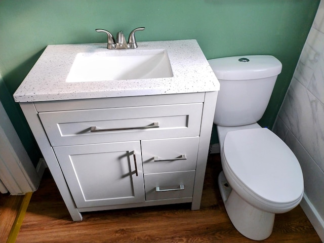 bathroom featuring toilet, vanity, and hardwood / wood-style floors