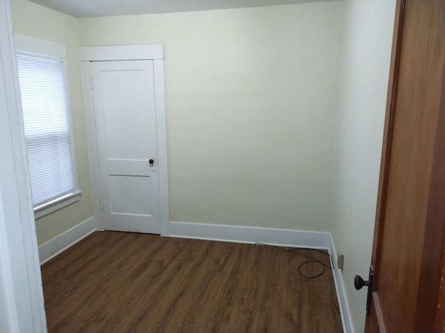 unfurnished room featuring dark wood-type flooring