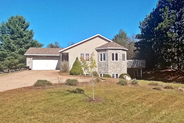 view of front of home with a garage, a deck, and a front lawn