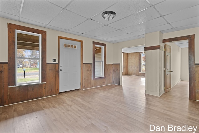 entryway featuring a paneled ceiling, wood walls, and light hardwood / wood-style flooring