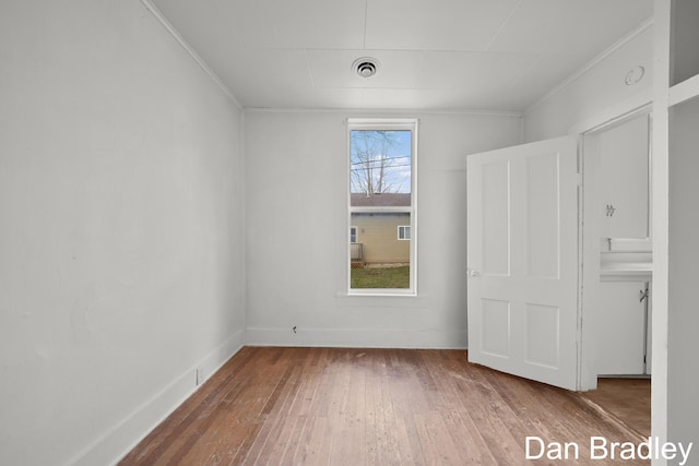 spare room with crown molding and hardwood / wood-style floors