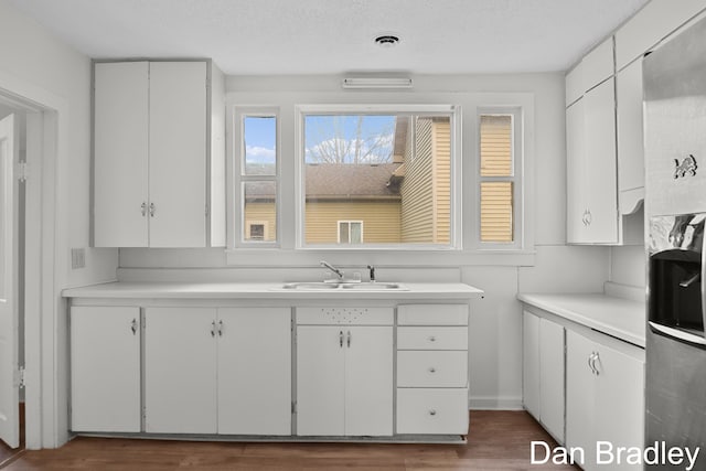 kitchen featuring white cabinetry, sink, dark wood-type flooring, and a textured ceiling