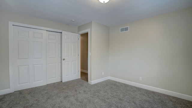 unfurnished bedroom featuring a closet, carpet flooring, visible vents, and baseboards