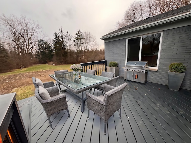 wooden deck with outdoor dining area and grilling area