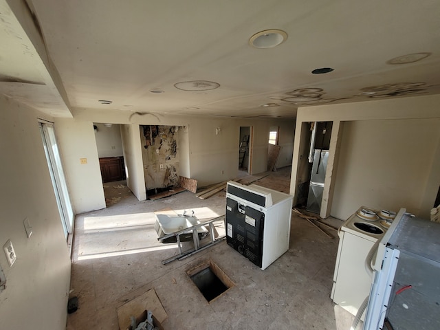 kitchen with white electric range oven, refrigerator, washer / clothes dryer, and stainless steel refrigerator