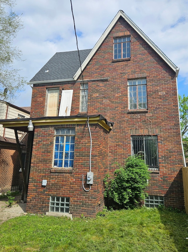 rear view of property featuring a lawn