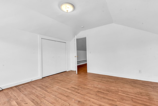 bonus room featuring light hardwood / wood-style floors, a baseboard radiator, and vaulted ceiling