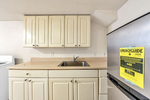 kitchen featuring white range, washer / clothes dryer, refrigerator, and sink