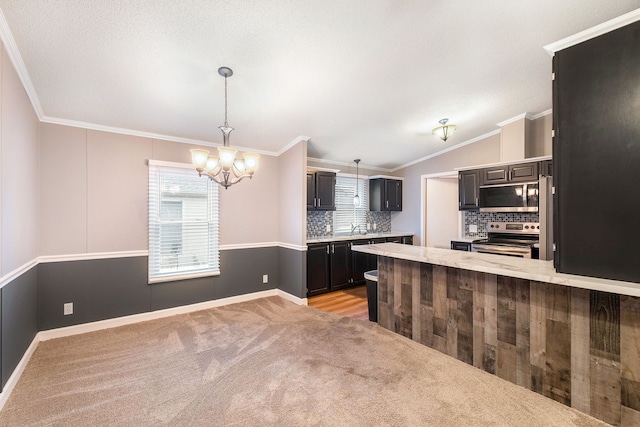 kitchen with light carpet, crown molding, tasteful backsplash, decorative light fixtures, and stainless steel appliances