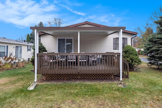 rear view of property featuring a wooden deck and a yard