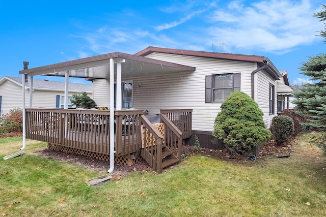 rear view of house with a lawn and a deck