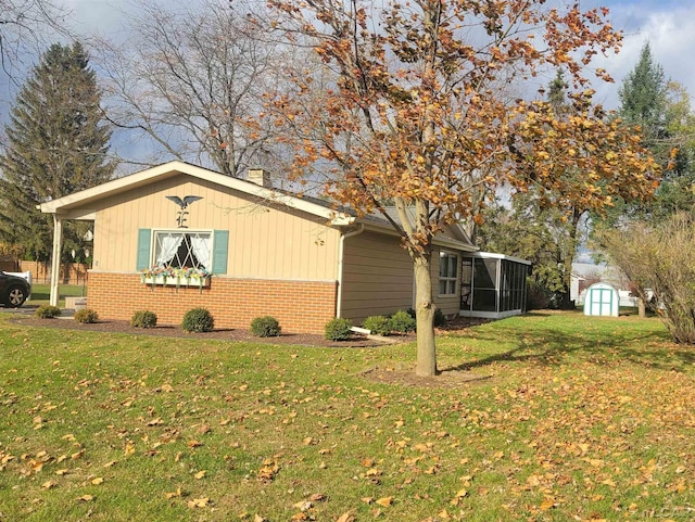 view of side of home with a yard and a storage shed