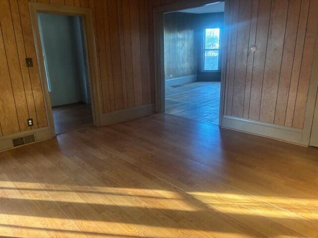 empty room featuring hardwood / wood-style floors and wooden walls