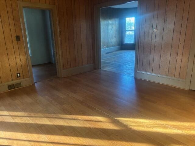 231 W Todd Ave, Reed City, MI 49677 - unfurnished room with wood finished floors, wood walls, and baseboards