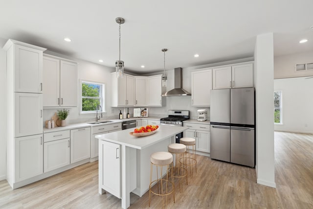 kitchen featuring white cabinets, wall chimney exhaust hood, sink, and stainless steel appliances