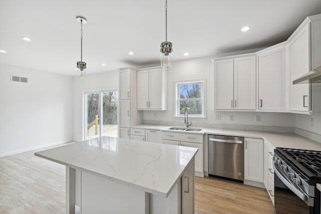 kitchen with plenty of natural light, decorative light fixtures, and appliances with stainless steel finishes