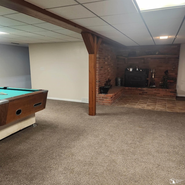 rec room with dark colored carpet, a paneled ceiling, a wood stove, and pool table