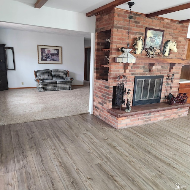 living room featuring hardwood / wood-style floors, a brick fireplace, and beam ceiling