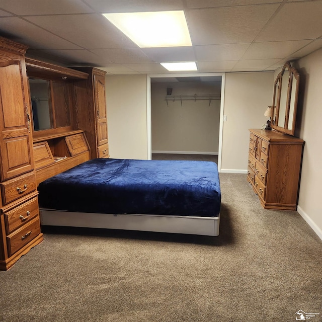 carpeted bedroom featuring a paneled ceiling and a closet