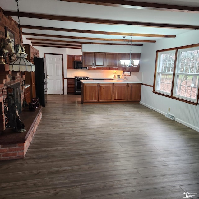 kitchen featuring sink, beamed ceiling, dark hardwood / wood-style floors, decorative light fixtures, and black appliances