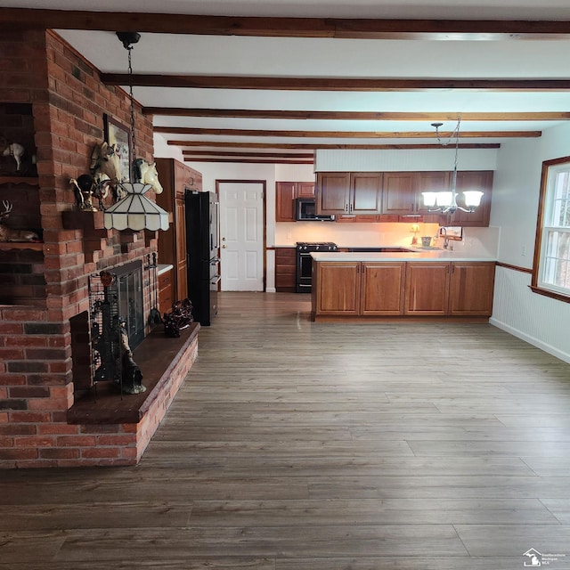 kitchen with black appliances, wood-type flooring, decorative light fixtures, beamed ceiling, and a chandelier