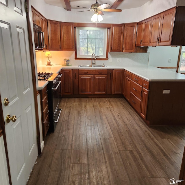 kitchen featuring ceiling fan, sink, black appliances, hardwood / wood-style flooring, and beamed ceiling