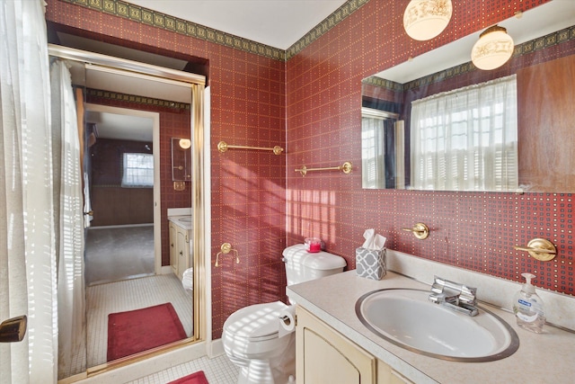 bathroom with toilet, tile patterned flooring, a healthy amount of sunlight, and vanity