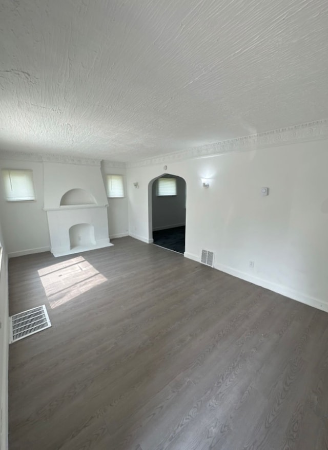 unfurnished living room with a textured ceiling and dark wood-type flooring