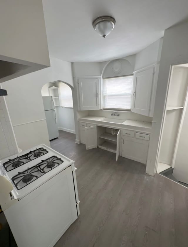 kitchen featuring white cabinetry, dark hardwood / wood-style floors, and white appliances