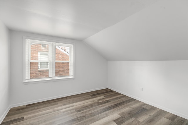 additional living space featuring hardwood / wood-style floors and lofted ceiling