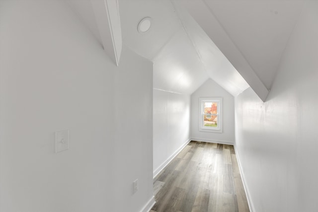 additional living space featuring hardwood / wood-style floors and vaulted ceiling