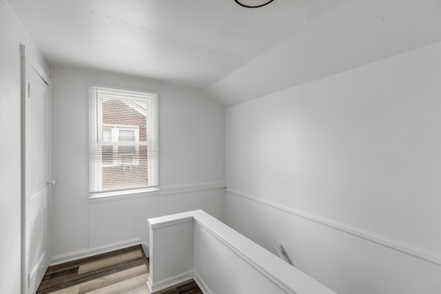 stairs featuring hardwood / wood-style floors and vaulted ceiling