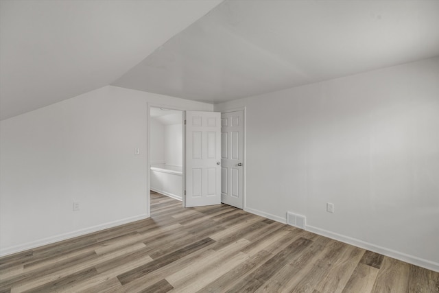 bonus room featuring lofted ceiling and light wood-type flooring