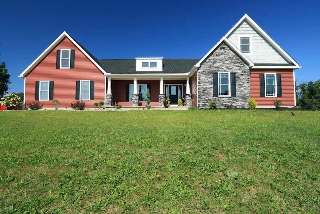 craftsman inspired home with a porch and a front yard