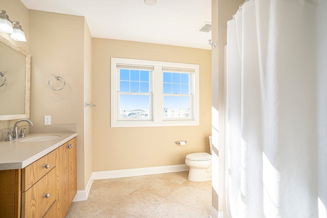 bathroom featuring tile patterned flooring, vanity, and toilet