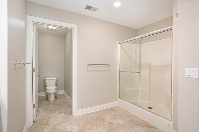 bathroom featuring toilet and an enclosed shower