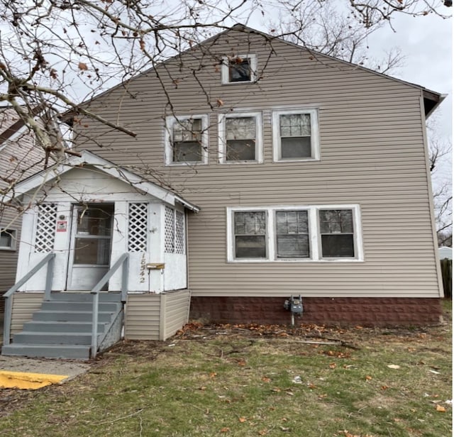 rear view of property with a yard