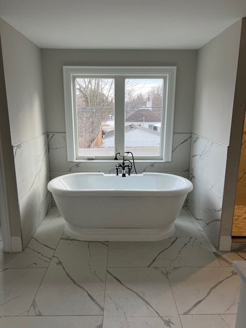 bathroom featuring tile walls and a tub