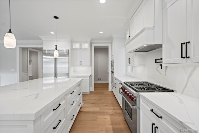 2182 Buckingham Ave, Birmingham, MI 48009 - kitchen with high end appliances, custom exhaust hood, white cabinets, light wood-type flooring, and crown molding