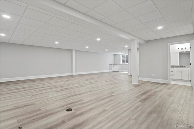 2182 Buckingham Ave, Birmingham, MI 48009 - unfurnished living room with light wood-type flooring, a paneled ceiling, baseboards, a sink, and recessed lighting