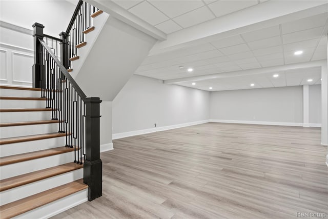 2182 Buckingham Ave, Birmingham, MI 48009 - below grade area with baseboards, stairway, light wood finished floors, a drop ceiling, and recessed lighting