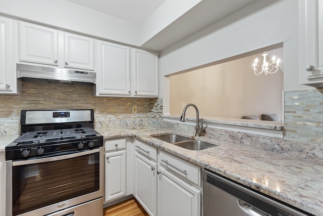 kitchen with white cabinets, sink, stainless steel appliances, and a chandelier