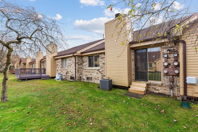 back of house with cooling unit, a wooden deck, and a lawn