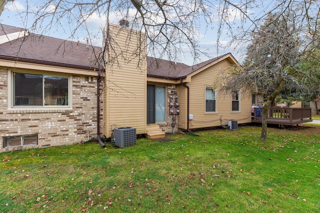 rear view of property with a yard and cooling unit