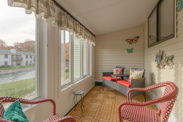 sunroom featuring a water view