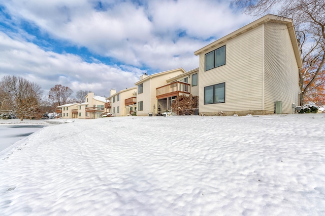 view of snow covered back of property